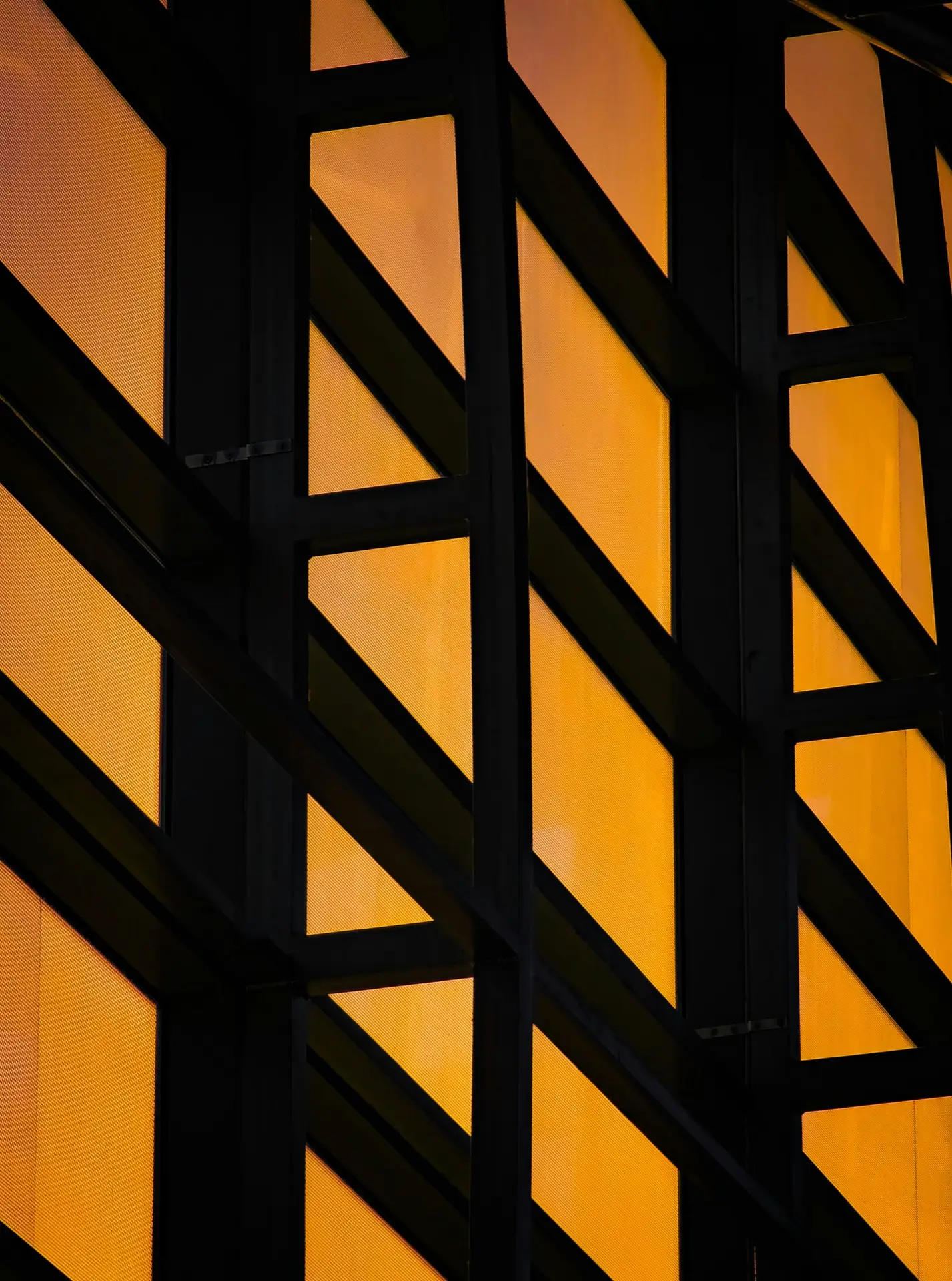 Gyldne facade-paneler med sorte diagonale bjaelker - moderne arkitektur